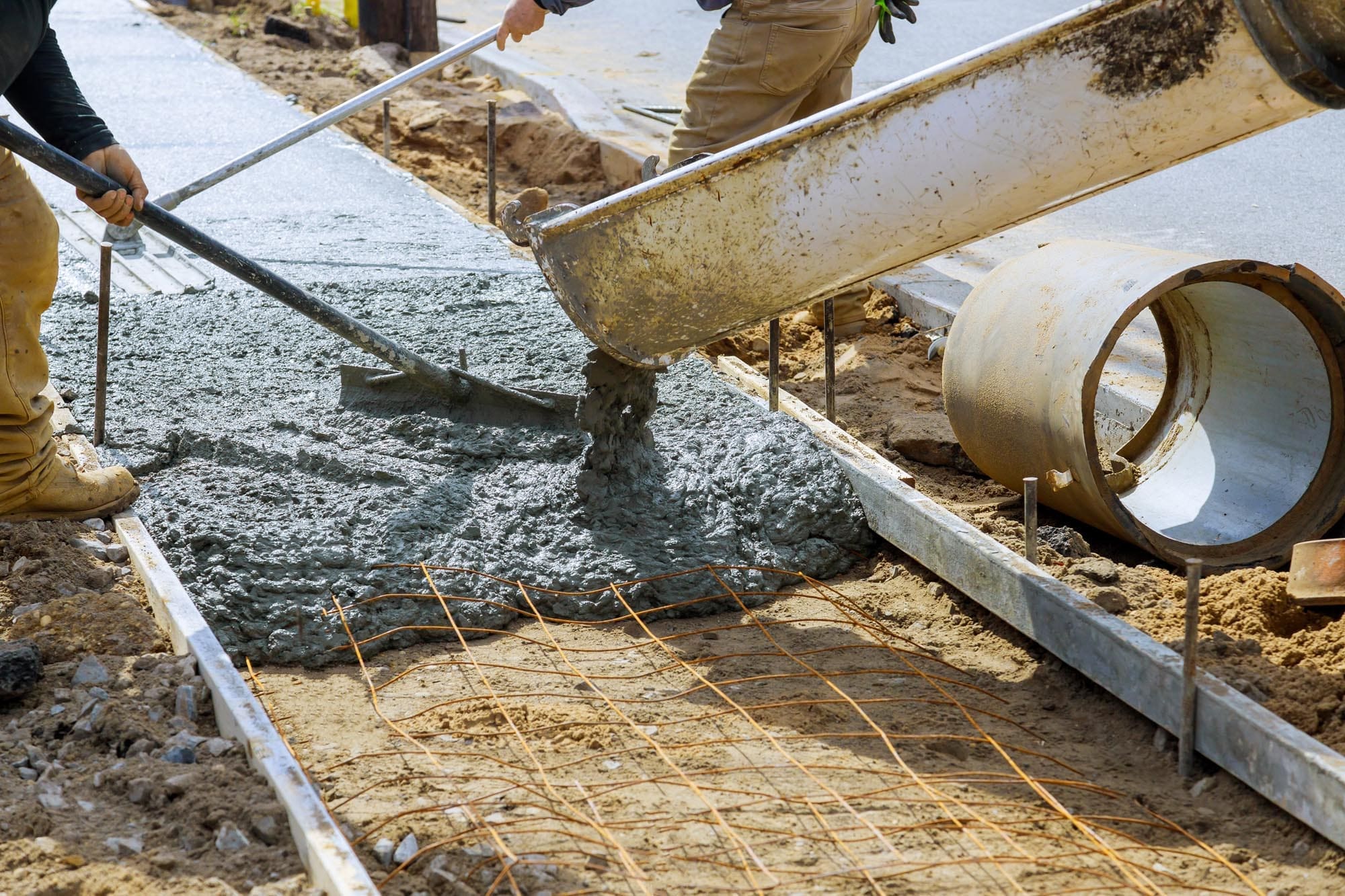 Cement truck mixer pouring fresh concrete on reinforced cement sidewalk