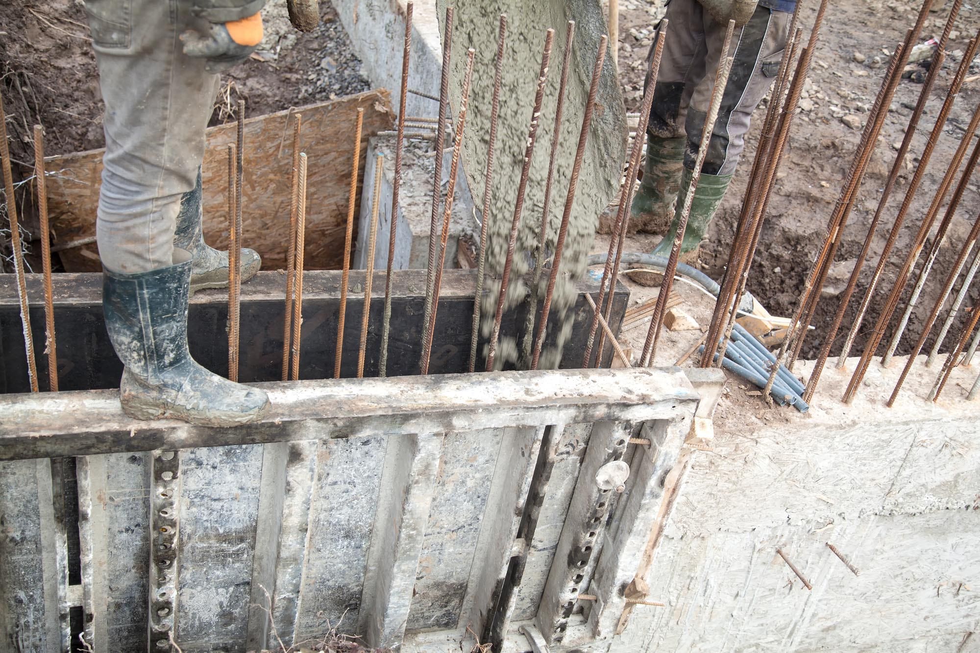 Pouring concrete into the construction of the house. Builders are pouring ready-mixed concrete